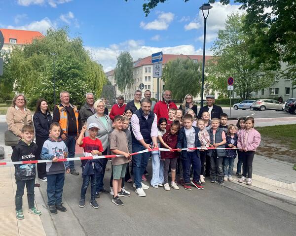 Bild vergr&ouml;&szlig;ern: Zur Freigabe der ersten beiden Bauabschnitte einer Geh- und Radwegtrasse durch die Stadt Calbe (Saale) durfte B�rgermeister Sven Hause (Bildmitte) Kinder des Lessing-Hortes, Vertreter der Baubetriebe STRABAG und Pfeiffer, der Calbenser Wohnungsbaugesellschaft, Planungsb�ro S2-Ingenieure PartmB sowie der Stadtverwaltung und des Stadtrates der Stadt Calbe begr��en.