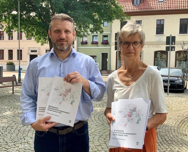 Bild vergrößern: Brgermeister Sven Hause und Fachdienstleiterin Katrin Mller halten einige druckfrische Exemplare des ISEK Calbe 2040 in ihren Hnden.